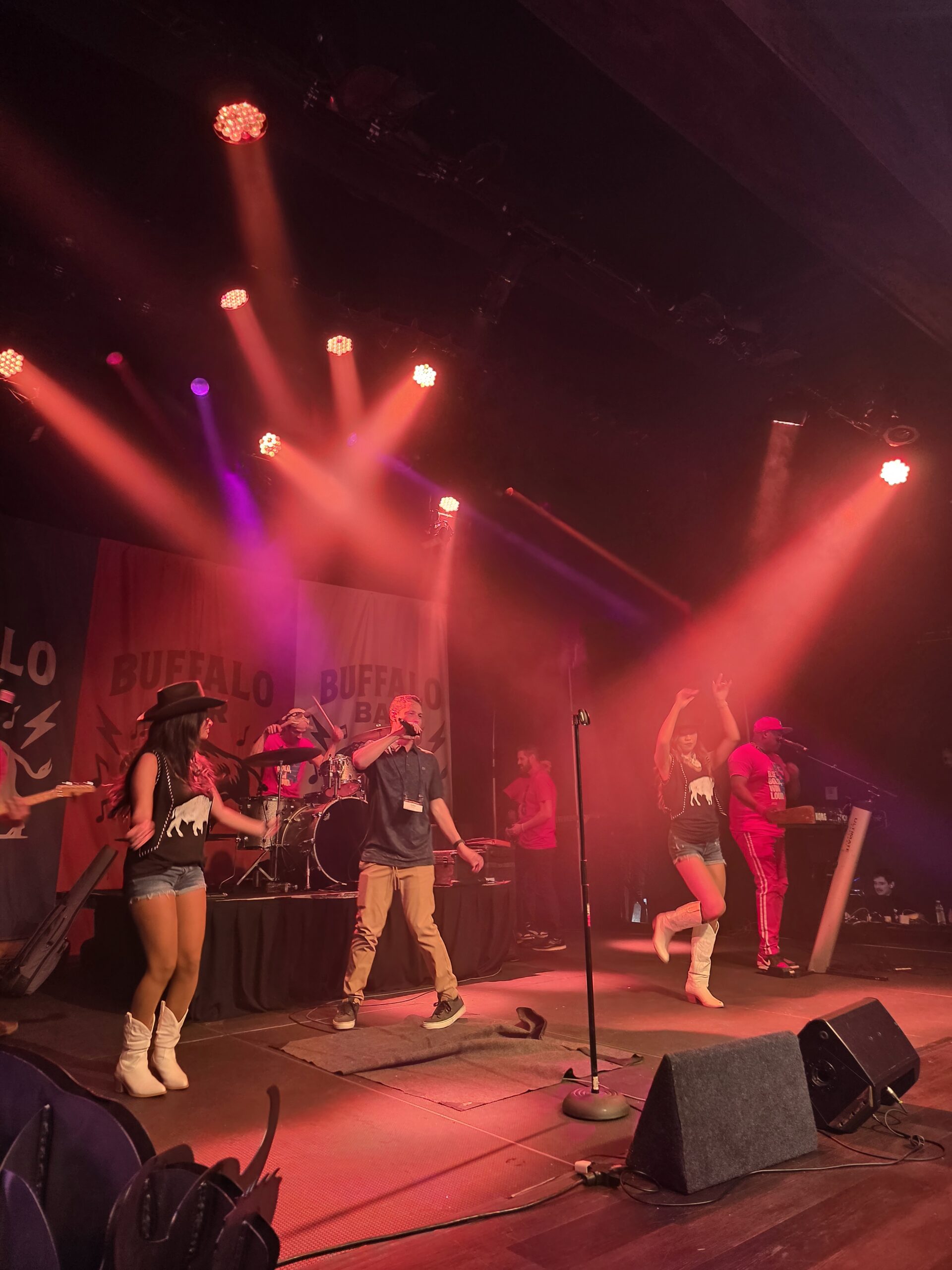 A guest singing onstage with the live band at a karaoke night